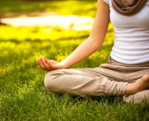 woman meditating on grass