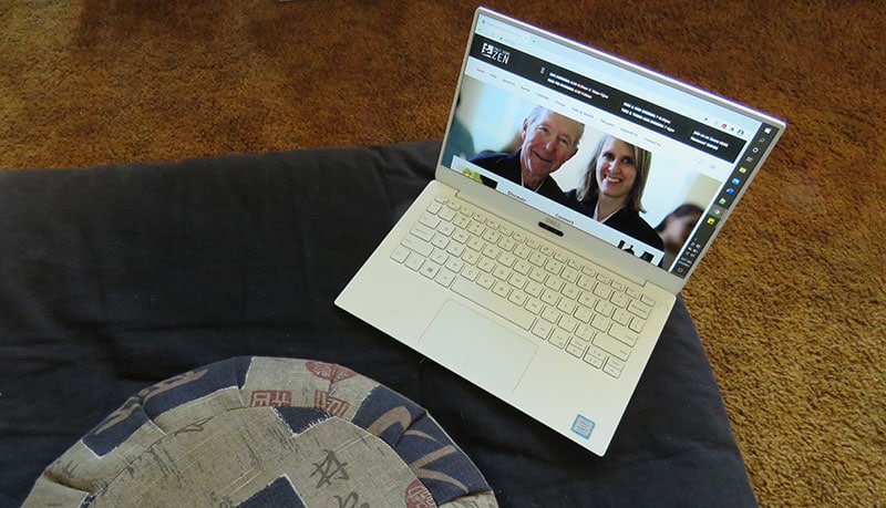 a meditation cushion and a computer open to the Zen Center website