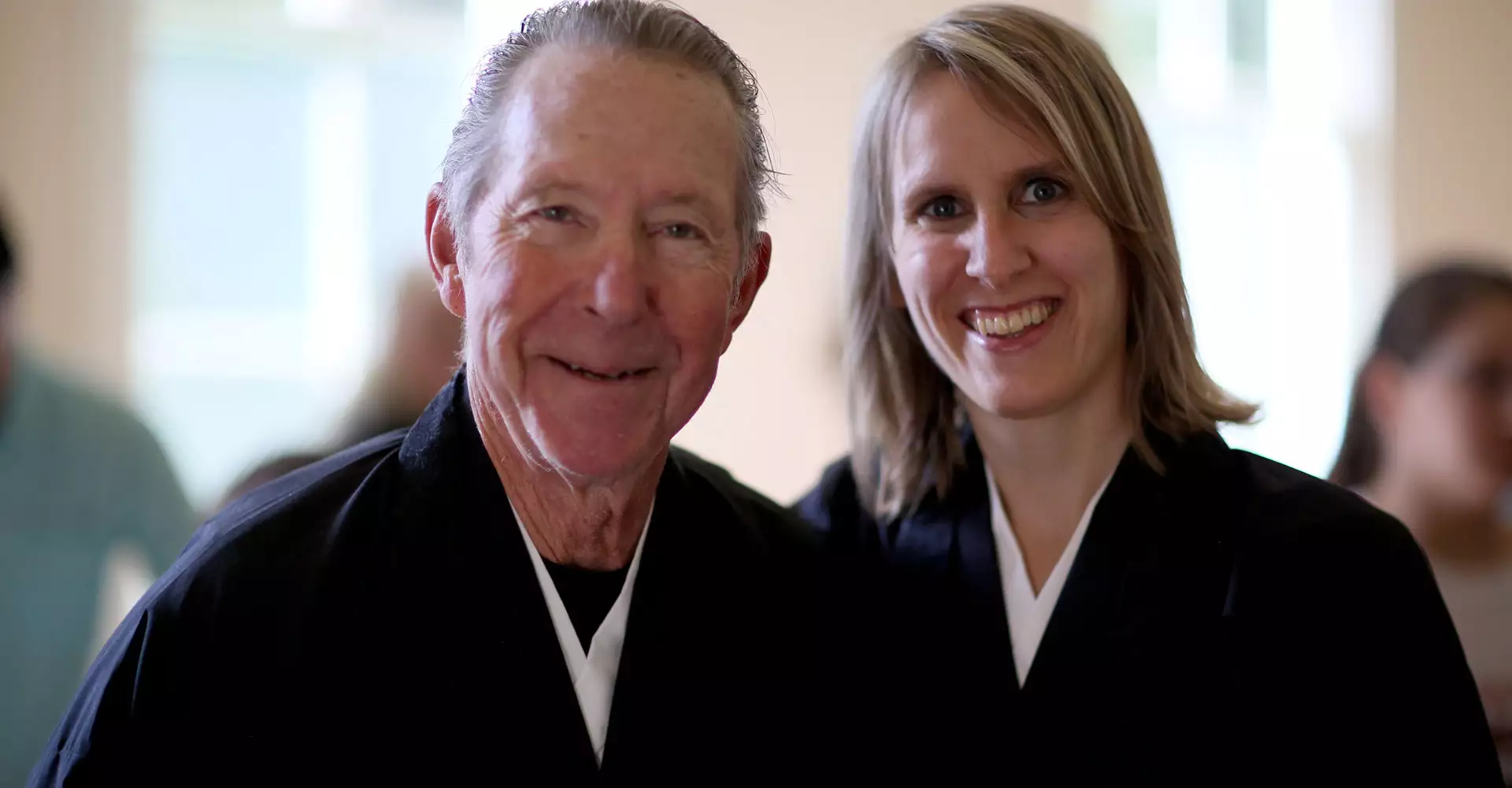 two Zen Center members wearing their Buddhist robes and smiling