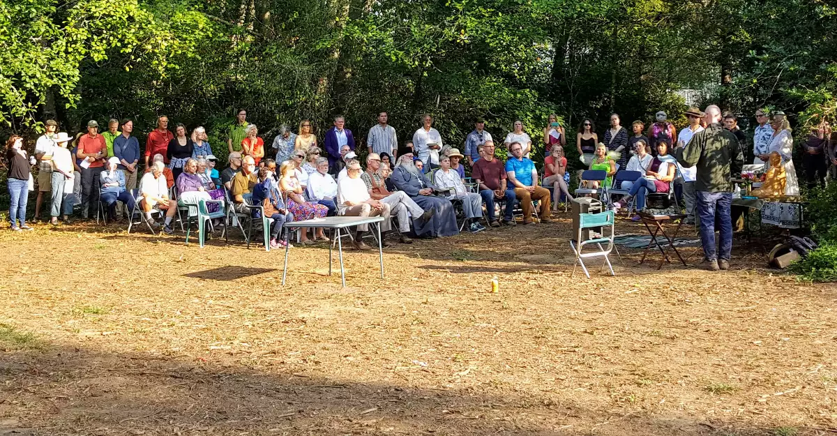 many people in chairs at the dedication of land which the Zen Center purchased
