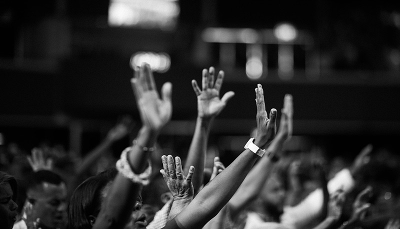 hands raised in protest at night, asking for racial justice..