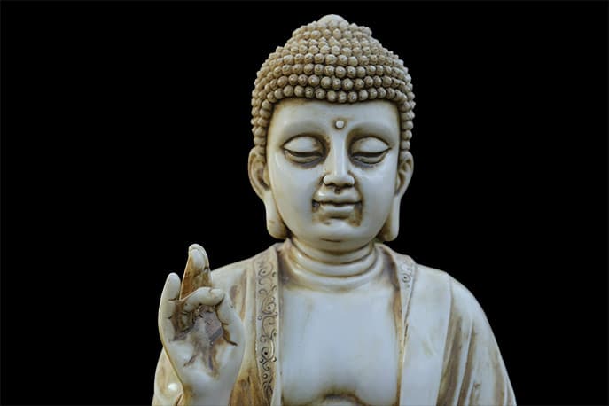 A torso of Buddha with hand raised signifying teaching