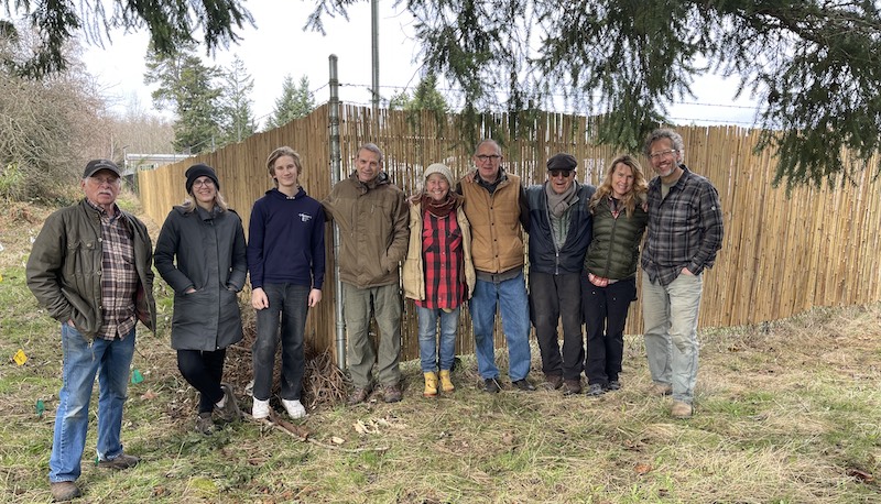 Sangha members standing in front of a newly completed fence on our Zen property.