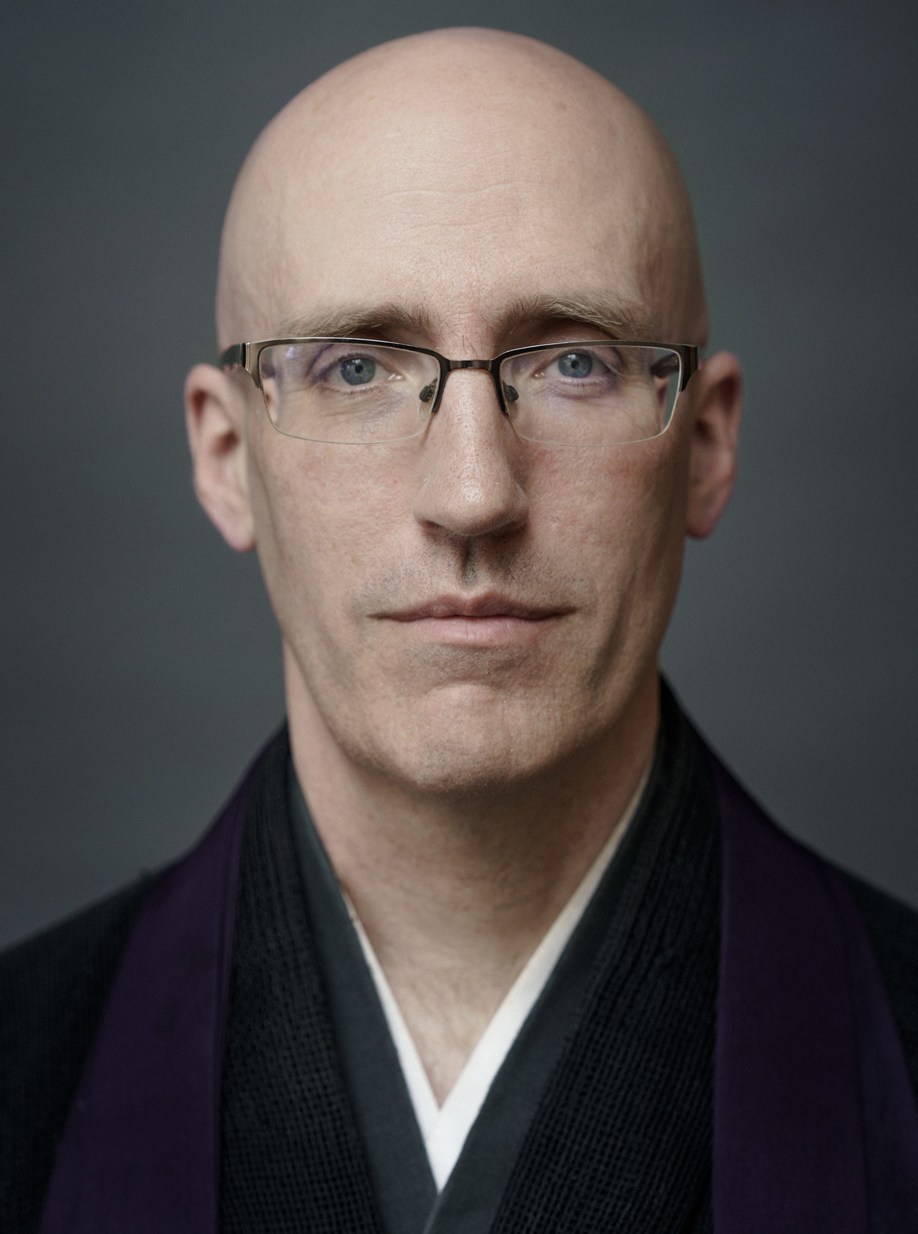 Head shot of Koshin in a black robe.